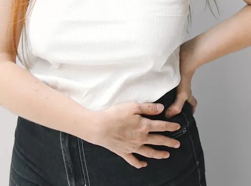 Primer plano de mujer tocándose el vientre